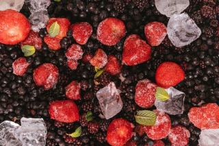 Fraises et framboises étalées séparément sur une plaque recouverte de papier cuisson, avant la mise au congélateur